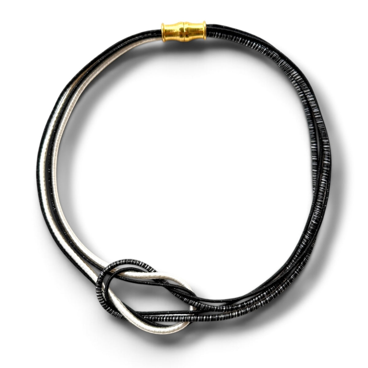 A double-strand black and silver beaded necklace with a twisted knot detail and a gold clasp, shown on a white background.