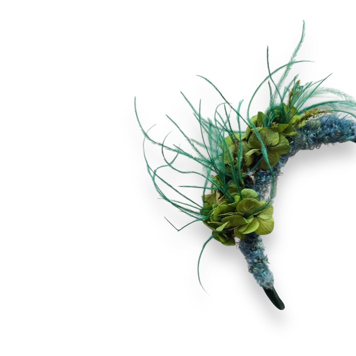 Handcrafted Wild Bloom Green headpiece with preserved green hydrangeas, teal ostrich feathers and blue-green detailing on a black velvet headband.