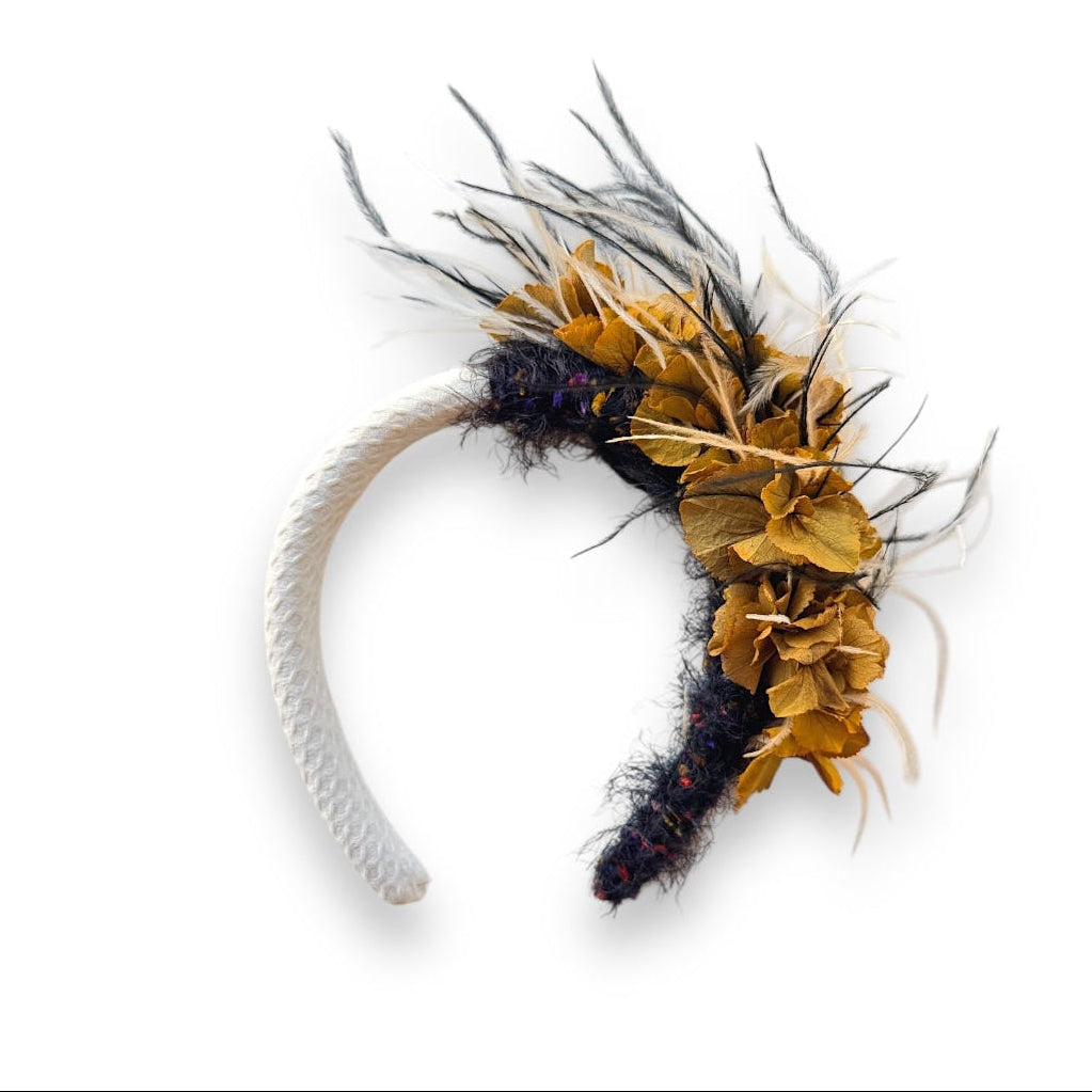 Handcrafted Wild Bloom Black & White headpiece with golden ochre preserved hydrangeas, black and white ostrich feathers and a white fabric-covered headband.