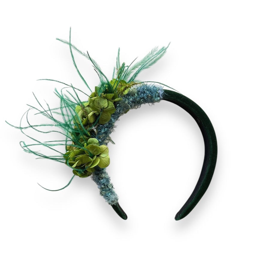 Handcrafted Wild Bloom Green headpiece with preserved green hydrangeas, teal ostrich feathers and blue-green detailing on a black velvet headband.