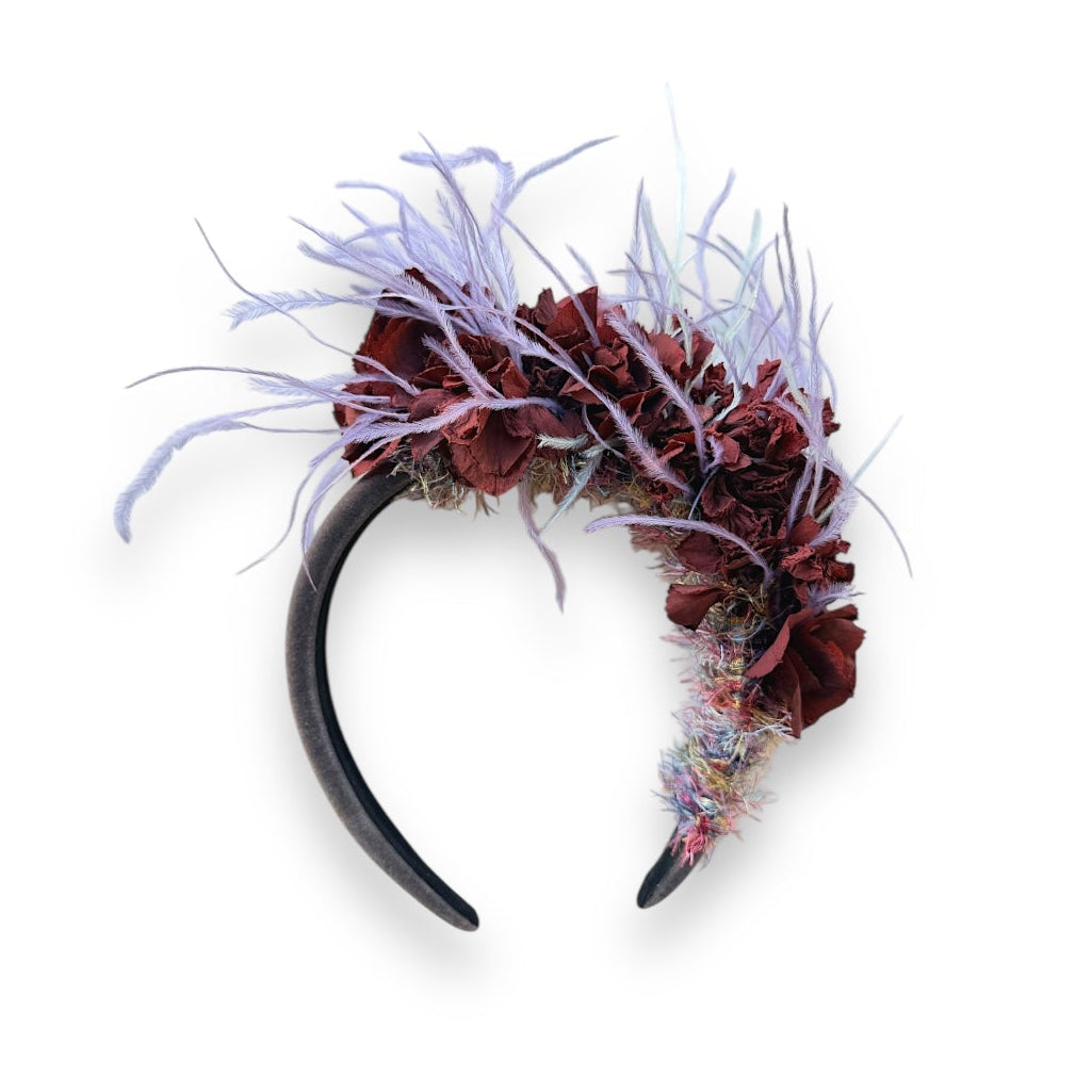 Handcrafted Wild Bloom Lavender Headpiece with deep burgundy-brown preserved hydrangeas, soft lilac and lavender ostrich feathers and textured yarn detailing on a dark velvet padded headband.