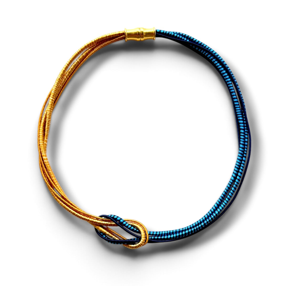 A multi-strand beaded necklace featuring gold and blue beads, arranged in a circular loop with a gold clasp and a knotted detail at the bottom, set against a plain white background.